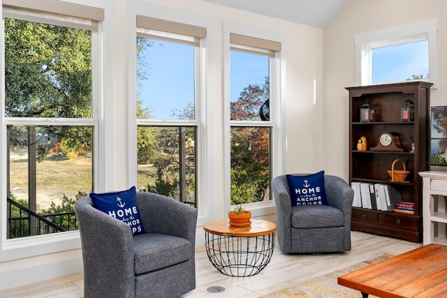 living area with lofted ceiling, plenty of natural light, and light hardwood / wood-style floors