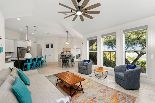 living room with light hardwood / wood-style flooring and ceiling fan