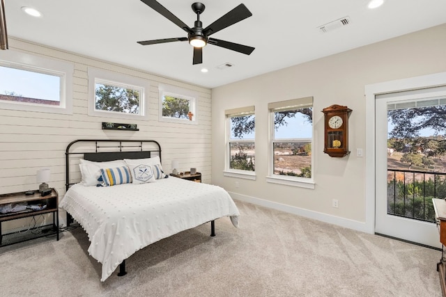 bedroom with multiple windows, light carpet, and access to outside