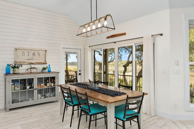 dining area featuring lofted ceiling and light wood-type flooring