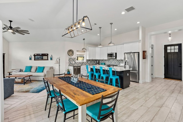 dining space featuring lofted ceiling, light hardwood / wood-style flooring, and ceiling fan