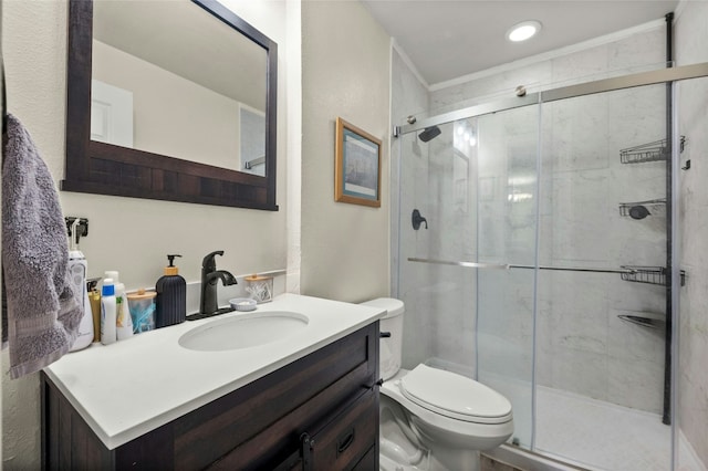 bathroom with vanity, an enclosed shower, and toilet