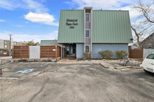 view of building exterior featuring stairway and fence