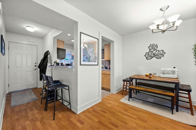 interior space with light wood-style floors, baseboards, and a notable chandelier