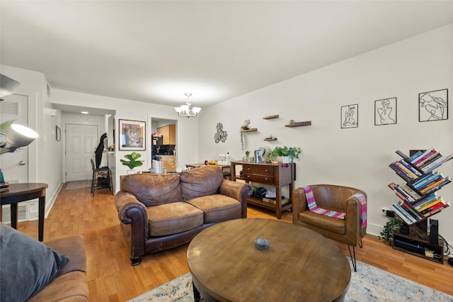 living room with an inviting chandelier and light hardwood / wood-style floors