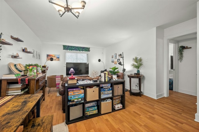 living room featuring an inviting chandelier and light hardwood / wood-style flooring