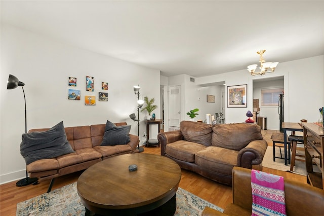 living room featuring a notable chandelier and light hardwood / wood-style floors