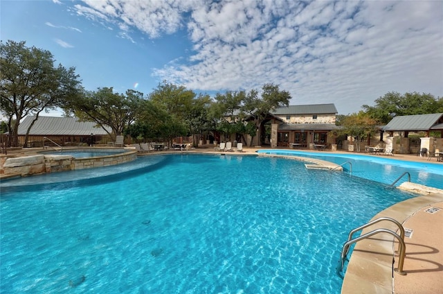 view of pool with a hot tub