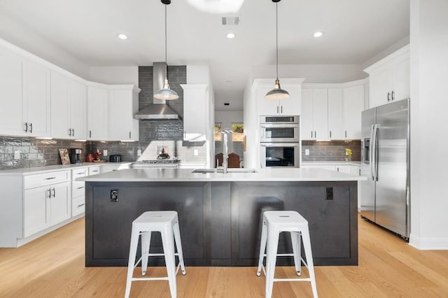 7224 Getaway Dr, Jonestown, TX 78645 - kitchen with appliances with stainless steel finishes, wall chimney exhaust hood, a sink, backsplash, and a breakfast bar area