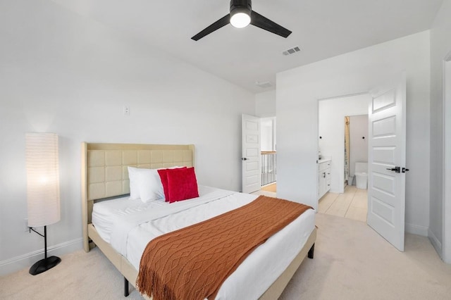 bedroom with light carpet, ceiling fan, and ensuite bath