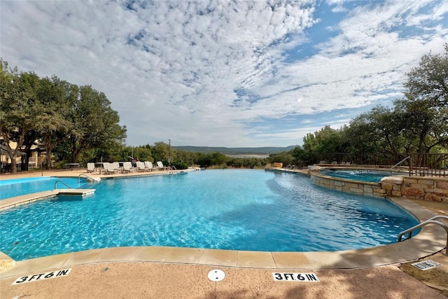 view of swimming pool with a community hot tub