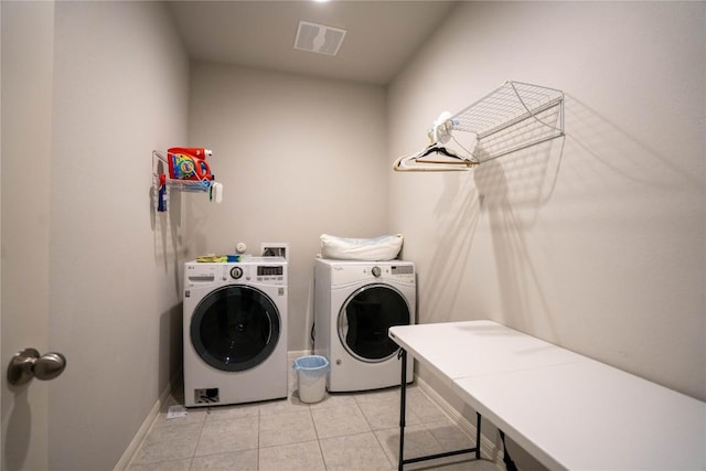 washroom with light tile patterned floors and washing machine and clothes dryer