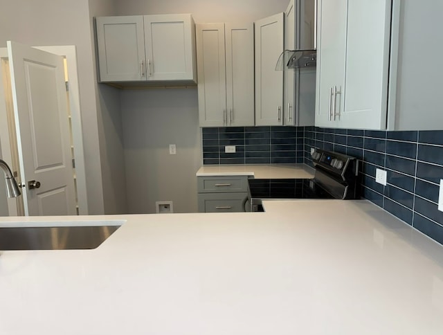 240 Shadow Oak Dr, Bastrop, TX 78602 - kitchen featuring black range with electric stovetop, a sink, backsplash, and light countertops