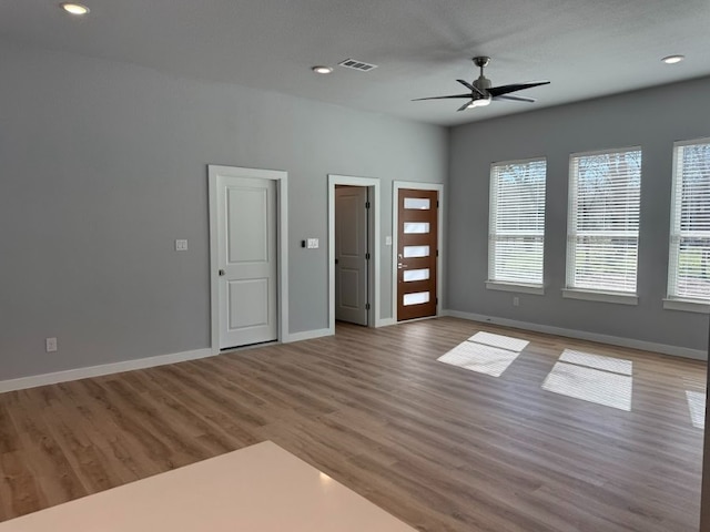 spare room with ceiling fan and light wood-type flooring