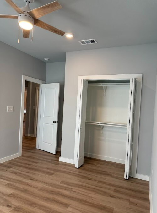 240 Shadow Oak Dr, Bastrop, TX 78602 - unfurnished bedroom with recessed lighting, baseboards, wood finished floors, a closet, and ceiling fan