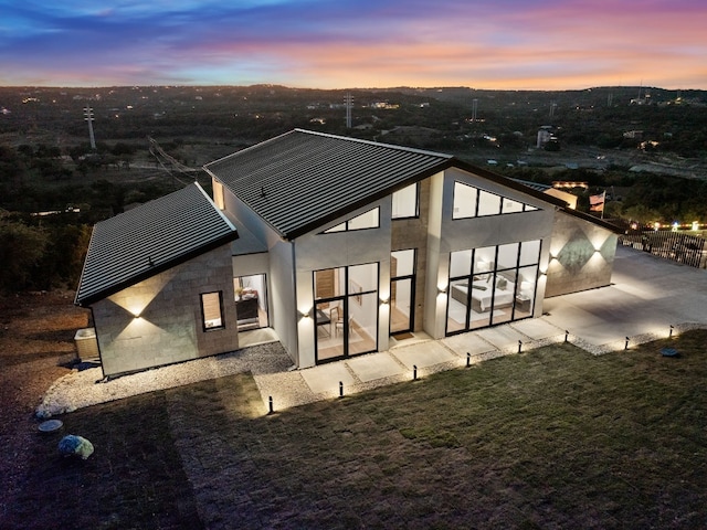 back house at dusk with a patio area