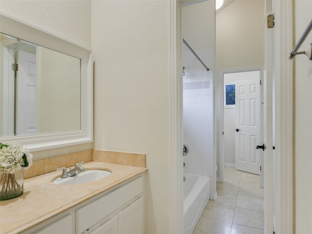 full bath with vanity, a textured wall, tile patterned flooring, and washtub / shower combination