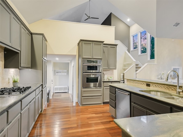 417 Beardsley Ln, Austin, TX 78746 - kitchen with stainless steel appliances, high vaulted ceiling, ceiling fan, gray cabinetry, and light wood-style flooring