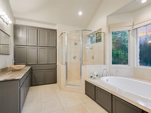 bathroom featuring a bath, tile patterned floors, vaulted ceiling, and a stall shower