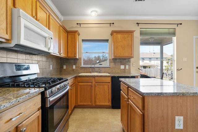 kitchen featuring stainless steel gas range oven, white microwave, ornamental molding, and a sink