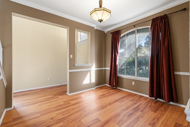 spare room with hardwood / wood-style flooring, a wealth of natural light, and ornamental molding