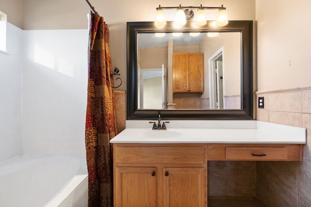 bathroom featuring vanity, tile walls, and shower / bath combo