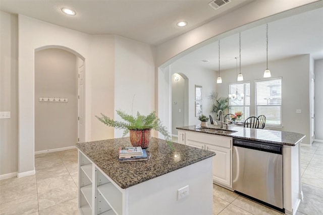 kitchen with sink, a kitchen island with sink, white cabinetry, hanging light fixtures, and stainless steel dishwasher