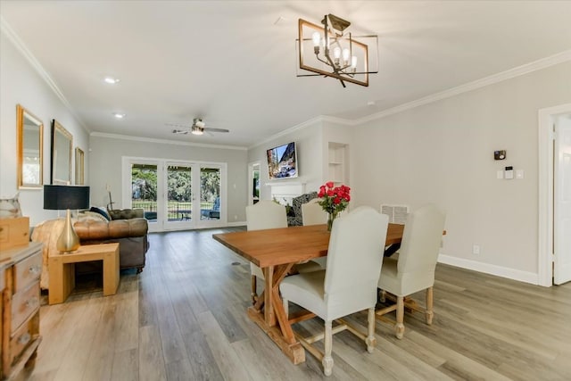 dining area with crown molding, wood-type flooring, and ceiling fan with notable chandelier