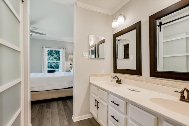 bathroom featuring crown molding, ceiling fan, backsplash, vanity, and wood-type flooring