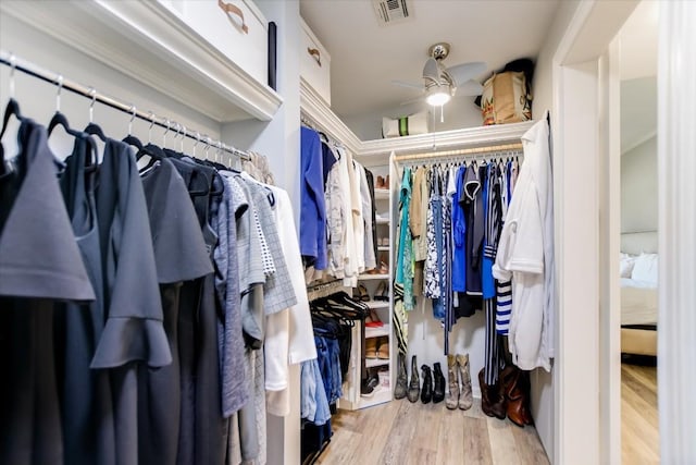 spacious closet with ceiling fan and light hardwood / wood-style flooring