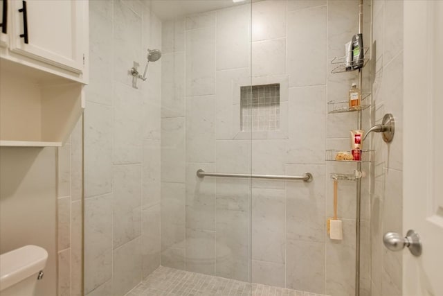 bathroom featuring toilet and tiled shower