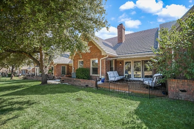 back of property with a yard, outdoor lounge area, and a patio area