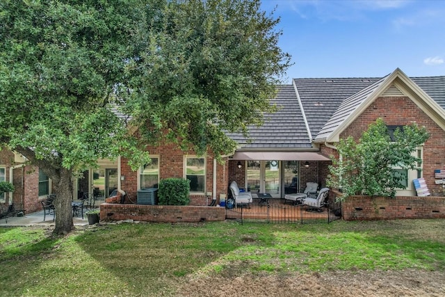 back of property featuring a yard, cooling unit, a deck, and a patio area