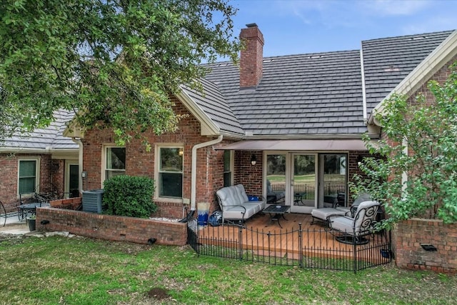 rear view of property with a yard, central AC unit, and a patio area