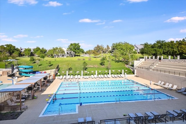 view of swimming pool with a patio and a water slide