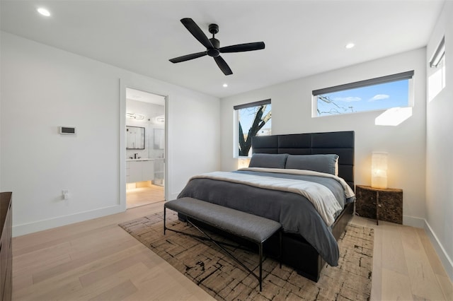 bedroom featuring sink, light hardwood / wood-style flooring, ceiling fan, and ensuite bathroom