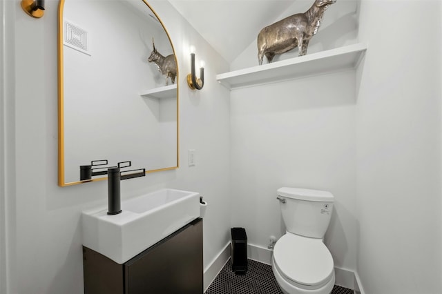 bathroom with vanity, toilet, and vaulted ceiling