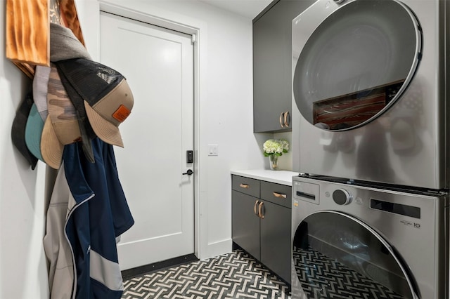 washroom featuring cabinets and stacked washer / drying machine