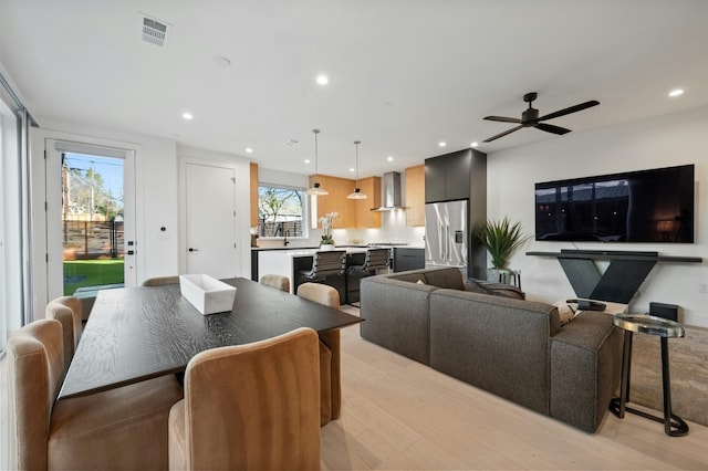 dining room with ceiling fan and light wood-type flooring