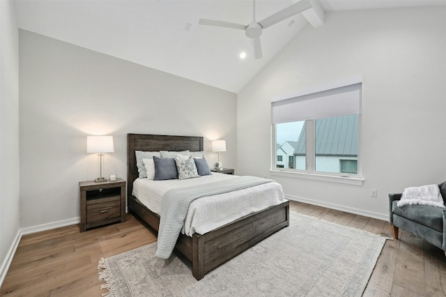 bedroom with ceiling fan, wood-type flooring, beam ceiling, and high vaulted ceiling