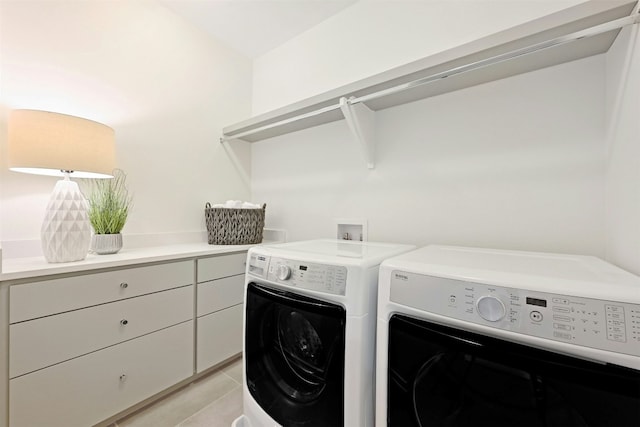 laundry area with washer and clothes dryer and light tile patterned floors