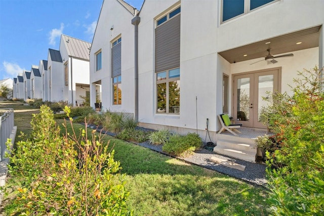 doorway to property featuring a lawn, ceiling fan, and french doors