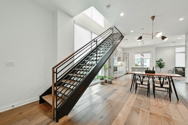 stairs featuring sink and hardwood / wood-style floors