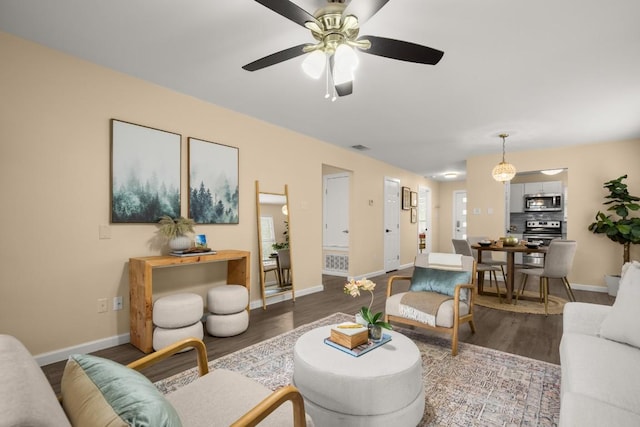 living room with dark hardwood / wood-style floors and ceiling fan