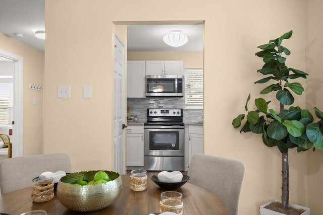 kitchen featuring appliances with stainless steel finishes, white cabinets, and decorative backsplash