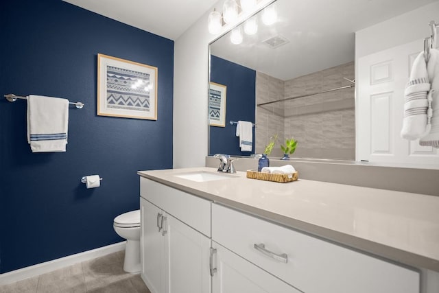 bathroom featuring vanity, tile patterned floors, toilet, and tiled shower