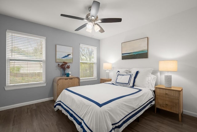 bedroom with multiple windows, dark wood-type flooring, and ceiling fan