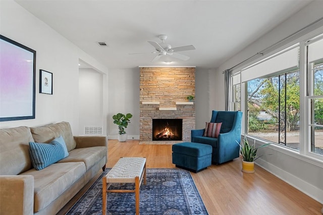 living room with ceiling fan, hardwood / wood-style floors, and a fireplace