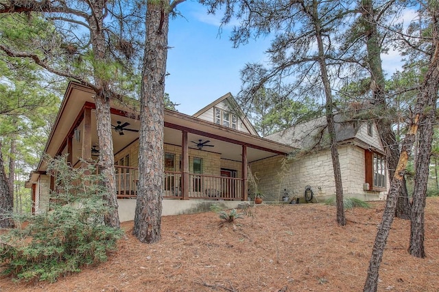 view of side of home with ceiling fan and a porch