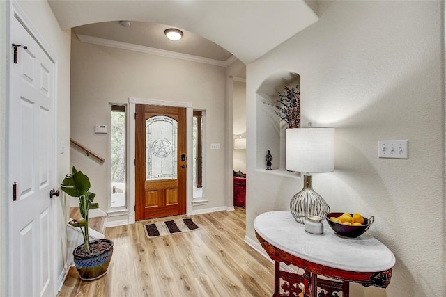 entrance foyer with ornamental molding and light wood-type flooring